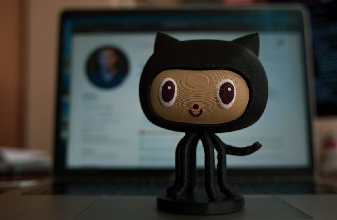 github cat mascot sculpture in front of laptop
